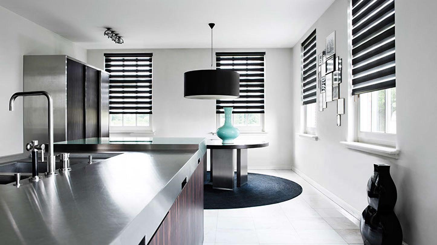 Striped double roller blinds on the windows of a modern white kitchen